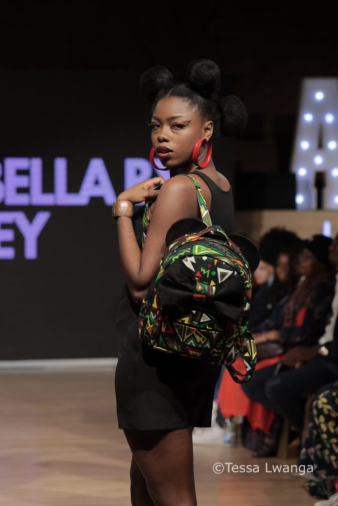 Model with afro hairstyle turns back to face audience at fashion show