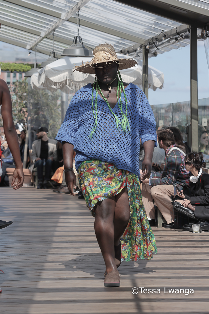 Sagaboi-0474 Model wears blue crotchet top and multicloured wrap at Sagaboi London Fashion week catwalk on partially shaded and sunny terrace in London.