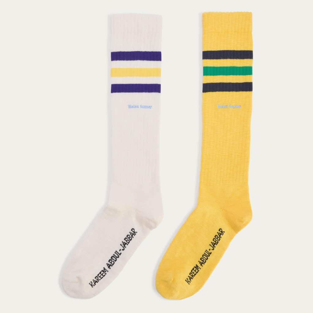 Beige and yellow sports socks with Adidas three stripes on white background
