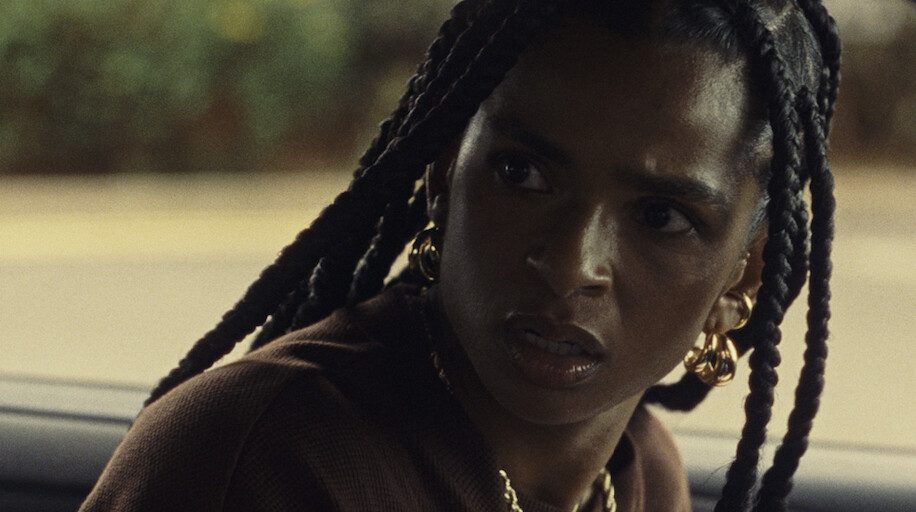 Image of black woman with braids looking back in anger